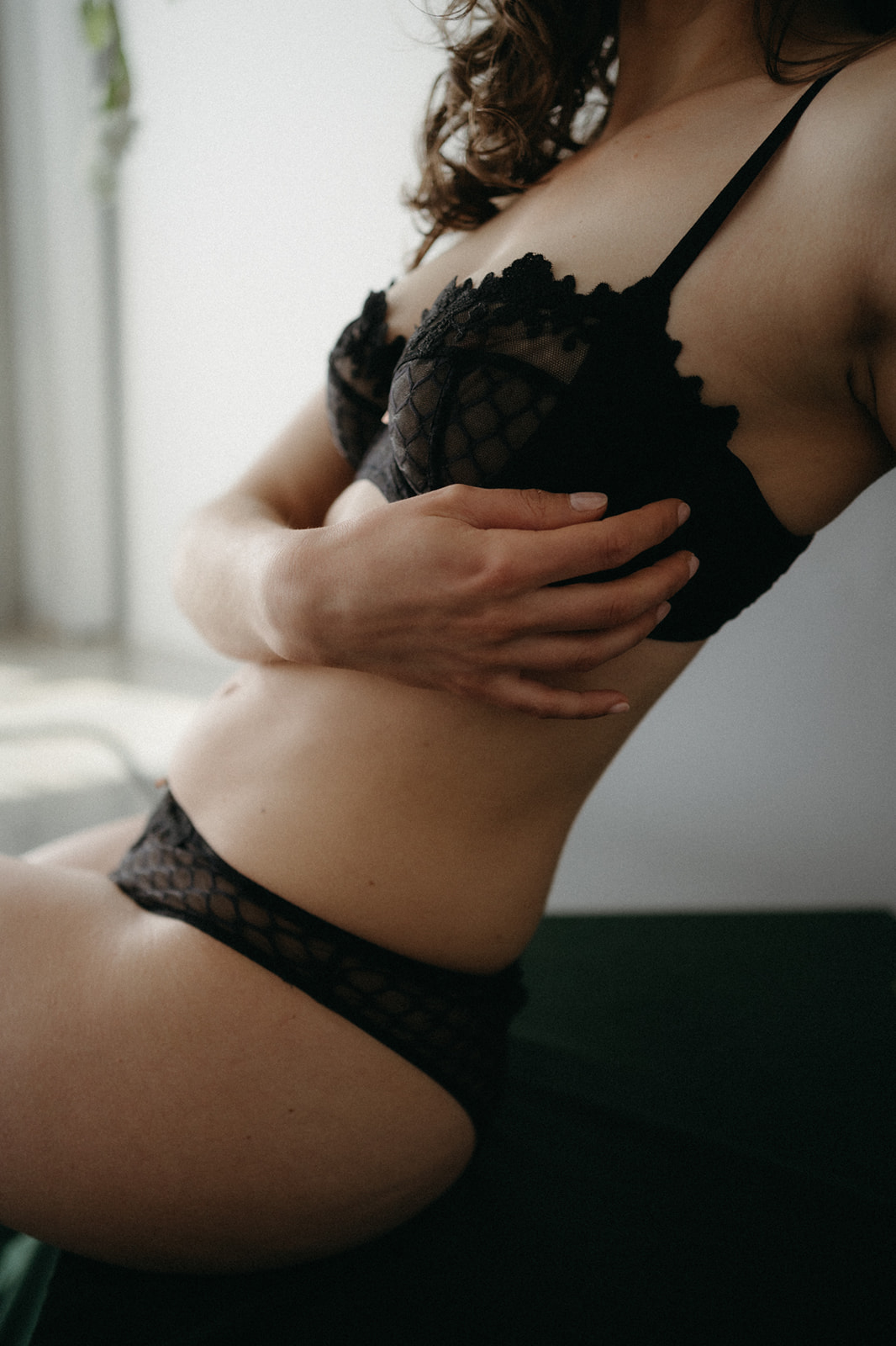 woman in black lace lingerie with her hand on her stomach
