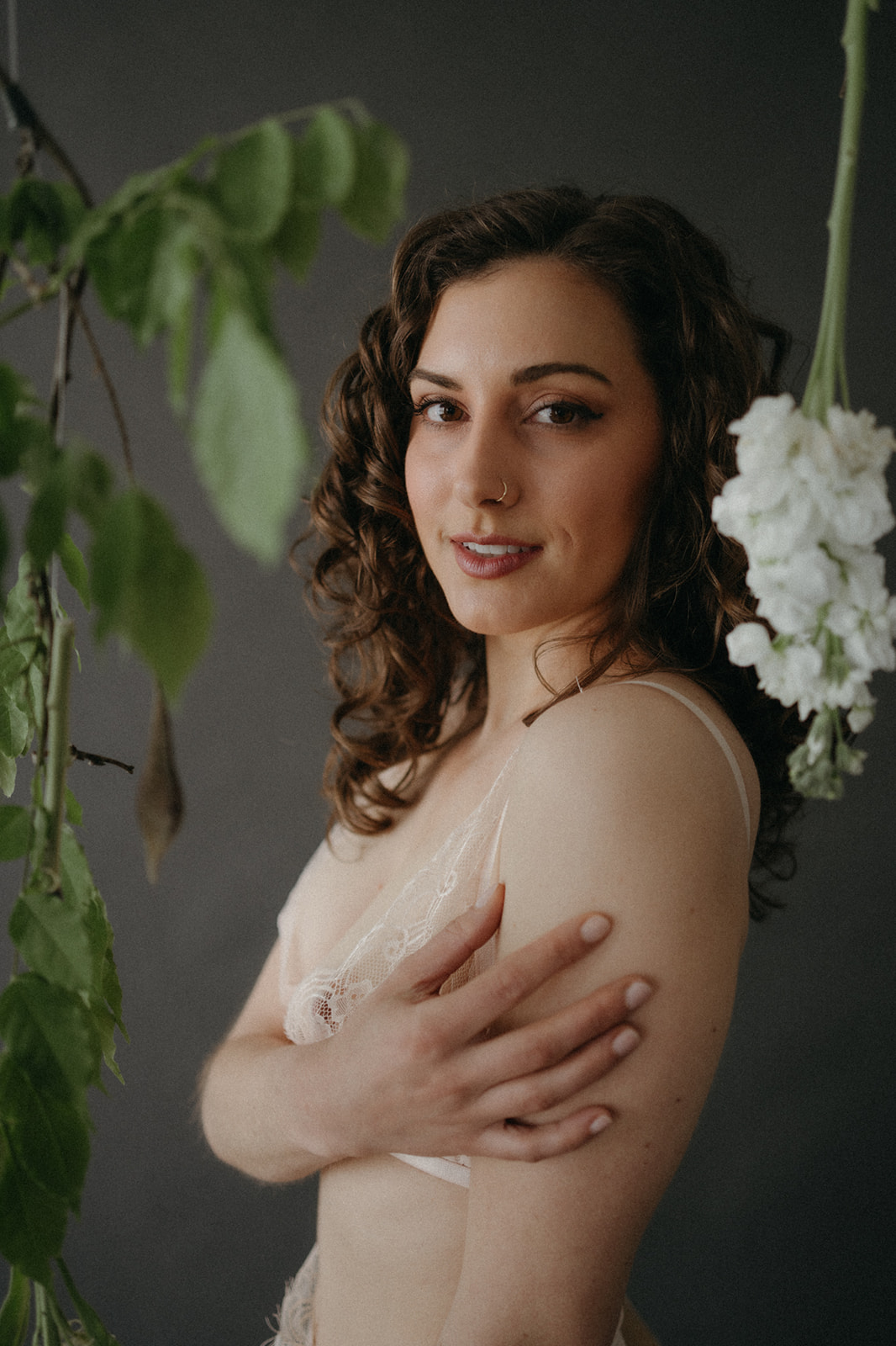 woman standing in greenery in white lace lingerie